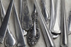 A row of tarnished silver flatware
