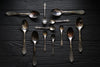 A collection of tarnished silver flatware in need of cleaning